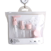 Travel Bottle Set containing six clear bottles with pink caps in a convenient travel bag.